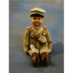 An English composition and fabric doll in soldier costume £90-120...