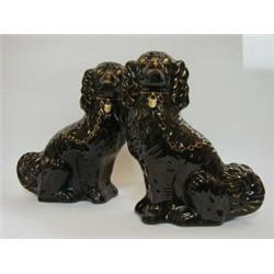 A PAIR OF STAFFORDSHIRE BLACK GLAZED SPANIELS, late 19th Century, soft gilt detailing, collars an...