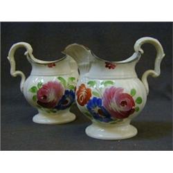 A PAIR OF PEARLWARE PITCHERS, c.1830, of Welsh type, boldly enamelled florally, height 17cm, (ref...