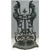 Image 1 : Un porte-parapluies d'angle en fonte orné de bustes casqués....
