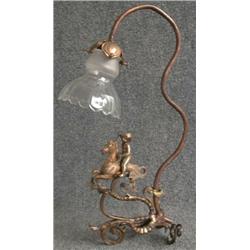 Une lampe en bronze patiné ornée d'un chérubin à cheval....