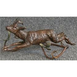 Une sujet en bronze de Vienne peint représentant un cerf bondissant au-dessus d'un fourré....