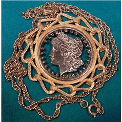 1880 Cut-out Morgan Silver Dollar in fancy bezel and suspended from a gold-plated chain.