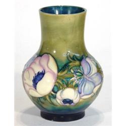 Moorcroft vase hand painted with an anemone pattern onto a green and blue ground, incised signatu…