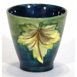 Moorcroft beaker decorated with two hand painted maple leaves onto a green and blue ground, impre…