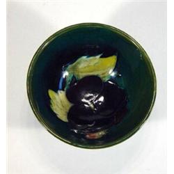 Small Moorcroft bowl hand painted with a purple pansy onto a green ground, paper label to base…