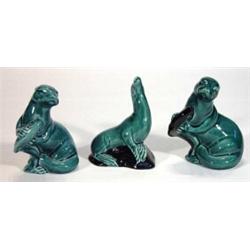 Turquoise glazed Poole otters catching fish and a sea lion on a rock, marks to base, largest 12cm…