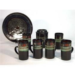 Celtic pottery Newlyn tray, six coffee cans and a sugar bowl and cover, paper labels to base…