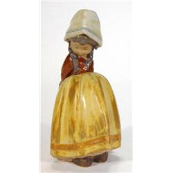 Lladro figurine of a girl with crossed arms in an orange and brown dress, printed marks to base…