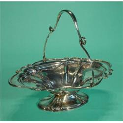 Shaped silver basket with swing handle and embossed with ribbons, 30cm in length, Sheffield 1904…