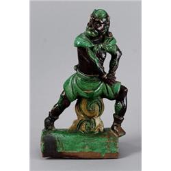 A MING GREEN- AND BLACKGLAZED EARTHENWEAR FIGURE,, A MING GREEN- AND BLACKGLAZED EARTHENWEAR FI...