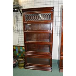 A five section mahogany stacking bookcase including one leaded panel