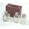 Image 1 : A set of three oblong glass scent bottles with silver plated screw covers, in brown leather case....