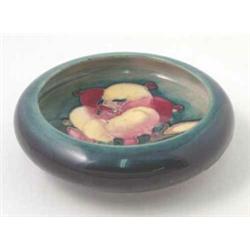 A small Moorcroft Fresia bowl, red and yellow petals against a deep green ground, impressed Potte...