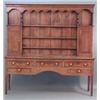 Image 1 : A George III oak dresser, the shelf back with waved pediment, shelves and two panelled doors over...