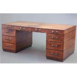 A large art deco walnut and rosewood crossbanded pedestal desk, with four frieze drawers over six...