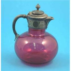 A Victorian ruby glass claret jug of globular form with plated mount....