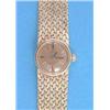 A lady's 18ct gold Omega wrist watch with circular gilt dial and integral textured bracelet....