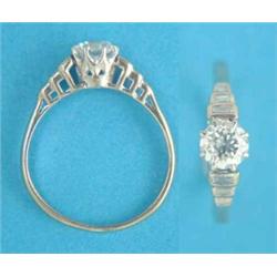 An 18ct white gold and platinum solitaire diamond ring, the stepped shoulders set baguette cut di...