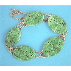 A Chinese gold and carved jade plaque bracelet...