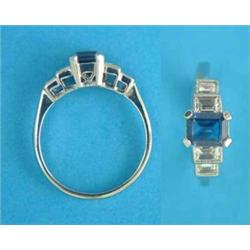 A white gold 5-stone sapphire and diamond ring, the rectangular cut sapphire flanked by baguette...