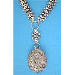 A late Victorian silver pendant locket, decorated with a horseshoe and flowerheads on a fancy lin...