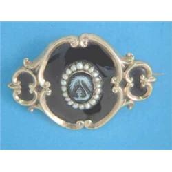 A Victorian gold mourning brooch, with carved hardstone cameo in a border of seed pearls, the rev...