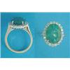 Image 1 : An 18ct gold cluster ring, claw-set with an oval emerald bordered by round cut diamonds...