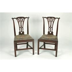 A SET OF FOUR GEORGE III MAHOGANY SIDE CHAIRS, in the Chippendale manner, with pierced vase shape...