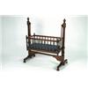 Image 1 : A MID-VICTORIAN MAHOGANY CRADLE, the rocking bassinet enclosed by turned spindles, hung from a tr...
