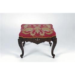 AN ANTIQUE FRENCH CARVED OAK FRAMED FOOTSTOOL, in the 18th century manner, upholstered in needlew...