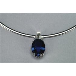 PLATINUM PENDANT, set with a fine fancy oval cut tanzanite (approx. 21.07ct.) surmounted by 3 tap...