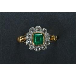 18K YELLOW GOLD AND PLATINUM RING, bezel set with an emerald cut emerald (approx. 0.64ct.) encirc...