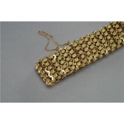 18K YELLOW GOLD BRACELET, formed of rows of stylized flowerheads, 107.6 grams, See illustration...
