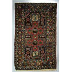 A SHIRVAN RUG, Caucasian, early 20th century, a pale red double keyhole motif medallion on a navy...