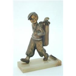 A Lorenzl spelter table lighter, modelled as a golfer, carrying a golfing bag, on a green onyx ba...