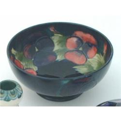 A Moorcroft bowl, the dark blue ground against tube-lined pansies, inscribed to base, Dia 6.25ins...