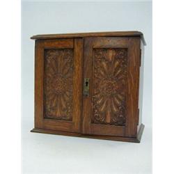 AN EDWARDIAN OAK SMOKERS CABINET, carved twin panelled doors, fitted interior, width 28cm  30-40...