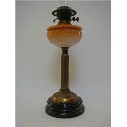 AN EDWARDIAN DUPLEX PARAFFIN LAMP, amber opaline reservoir, fluted brass column, black glazed cer...