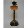 Image 1 : AN EDWARDIAN DUPLEX PARAFFIN LAMP, amber opaline reservoir, fluted brass column, black glazed cer...