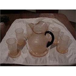 Pink water set, 6 glasses, 6 coasters, and pitcher w/saucer.  Pitcher has black handle.