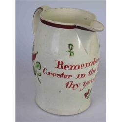 A late 18th century creamware jug, the bellied cylindrical shape painted with flowers below the red.