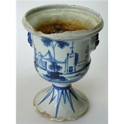 An 18th century Delft blue and white vase, the urn shape painted with churches either side of lion..