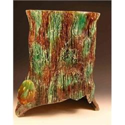 A mid Victorian majolica garden seat modelled as a tree trunk, the seat pierced with oval carrying..