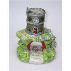 An early 19th century Walton pearlware folly, the grey tower on a green hill over a red arch and a..