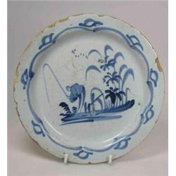 A mid 18th century Delft blue and white plate painted with a Chinese man fishing on an island by a..