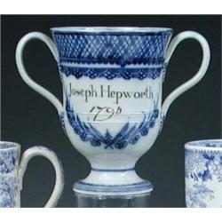 A blue and white pearlware loving cup inscribed in brown 'Joseph Hepworth 1795', the bell shaped bo.