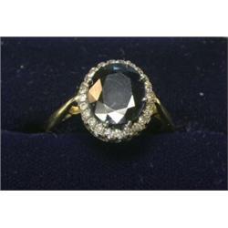 An 18ct gold ring with large oval sapphire within a diamond surround  £180-220...