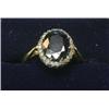 Image 1 : An 18ct gold ring with large oval sapphire within a diamond surround  £180-220...
