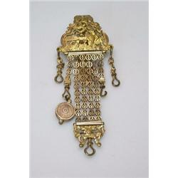A 19th century gilt metal chatelaine, the clip pierced and cast with mythological figures, suspende.